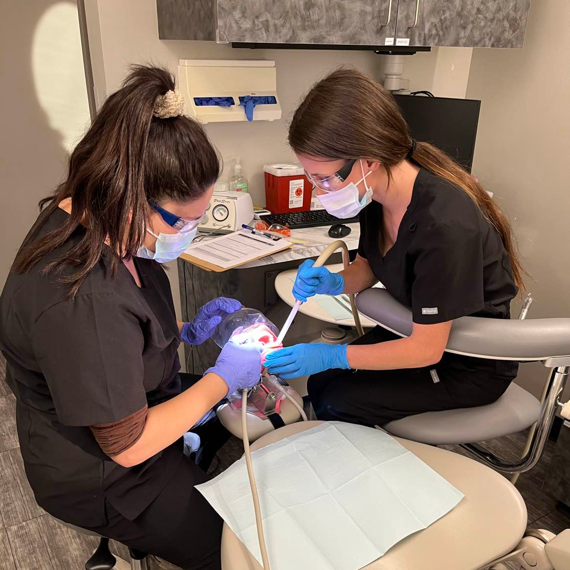 Dental assistant preparing equipment in a modern clinic.